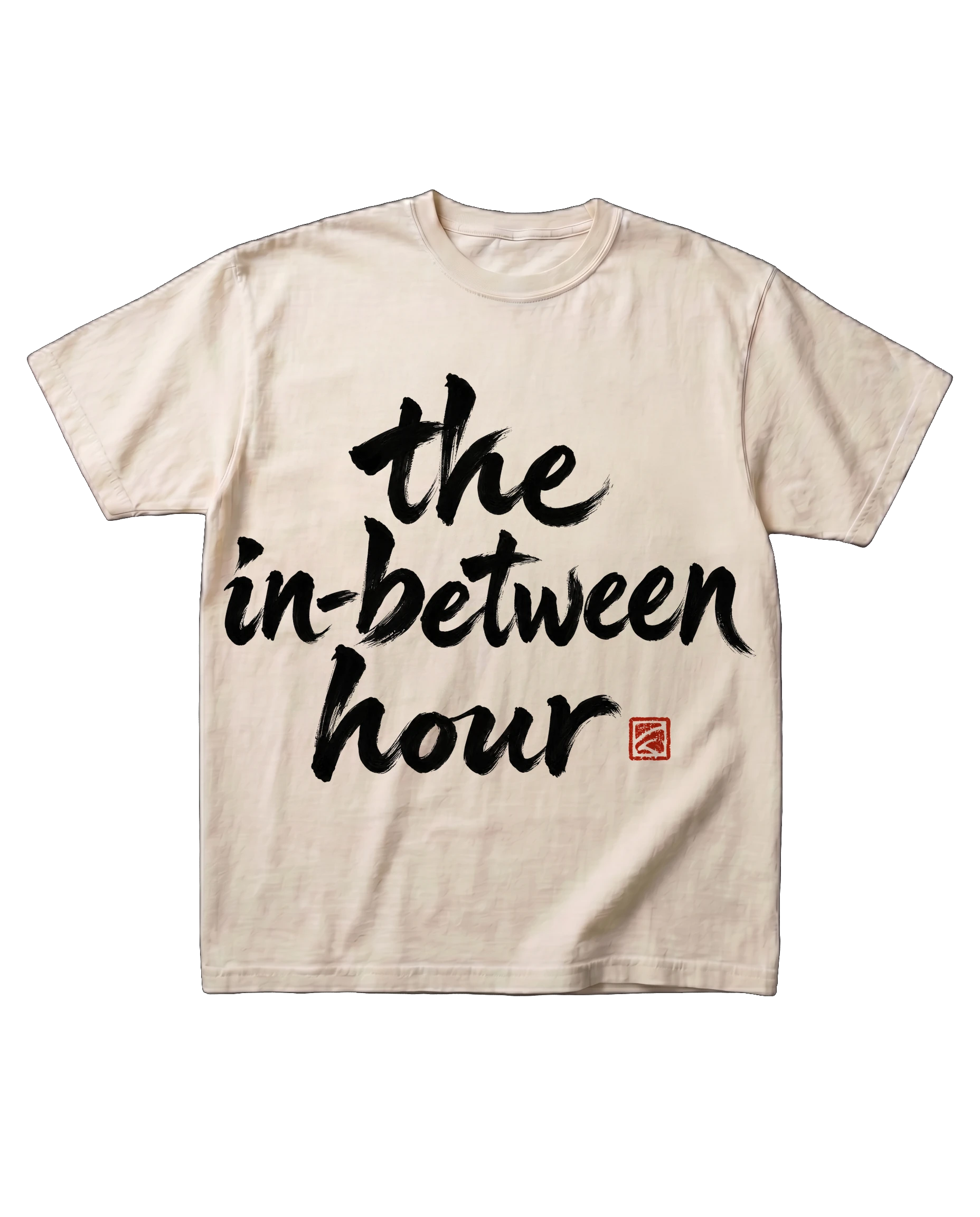 The in-between hour tee in Bone, laid flat: the words 'the in-between hour' brushed in sumi-ink calligraphy, with a small red seal.